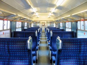 the interior of the class 421 shows an open plan layout with blue 4x4 seating either side