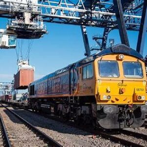 A class 66 hauling container wagons at a port-side rail terminal